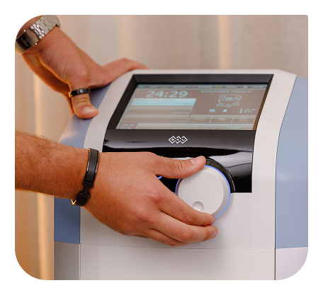 Hands adjusting the EMSELLA control panel.