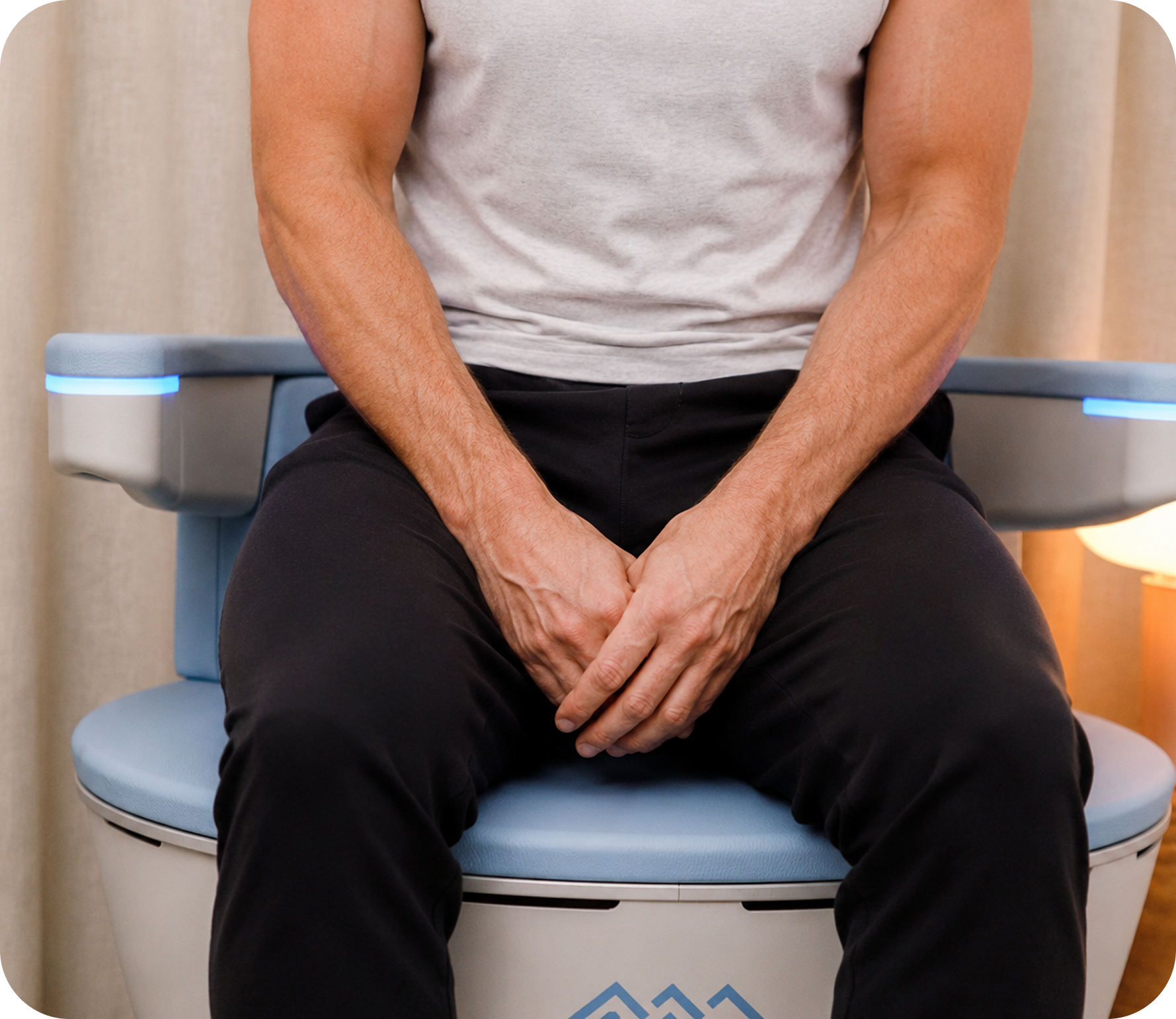 Man in everyday clothing seated on the EMSELLA treatment chair.